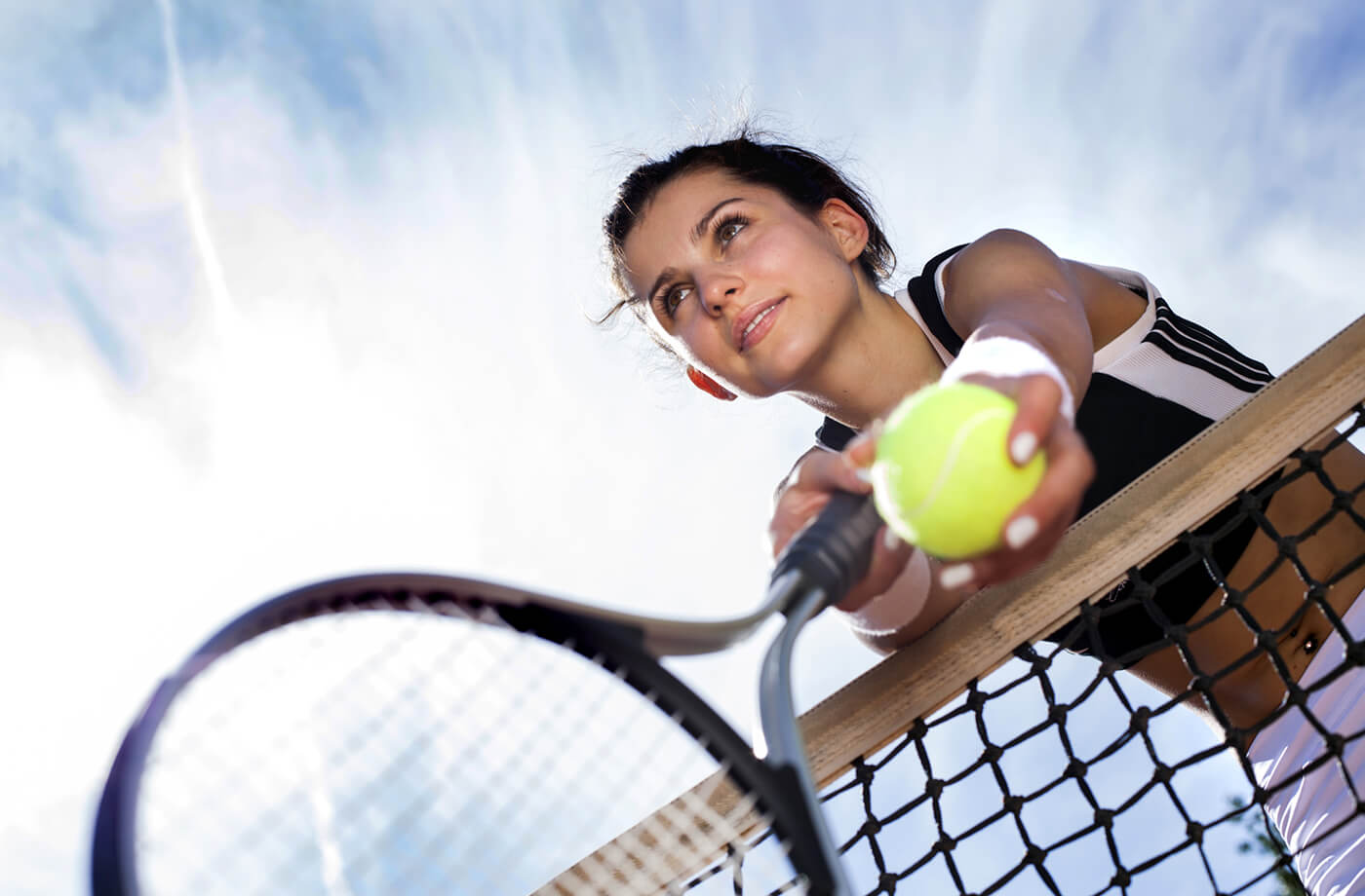 tennis player leaning over the net