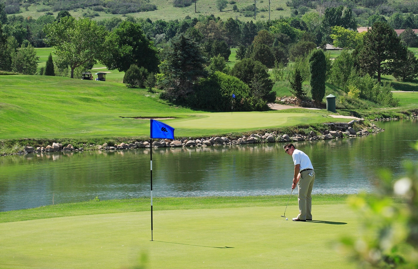 golfer on green by waterway