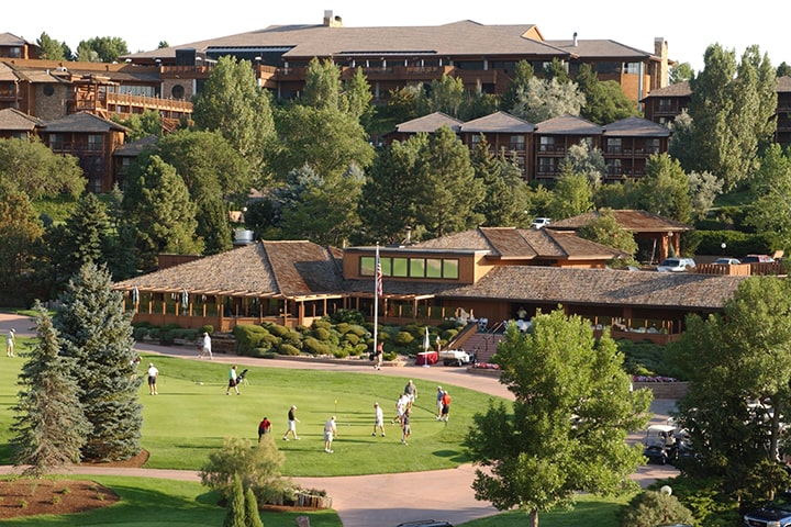 golfers on the green next to clubhouse